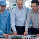 Engineering team discussing PCB and PCBA manufacturing projects inside an electronics production facility